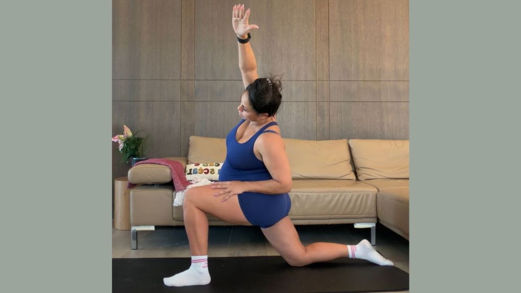 Pregnant woman doing a psoas release lunge stretch on an exercise mat to help turn a breech baby